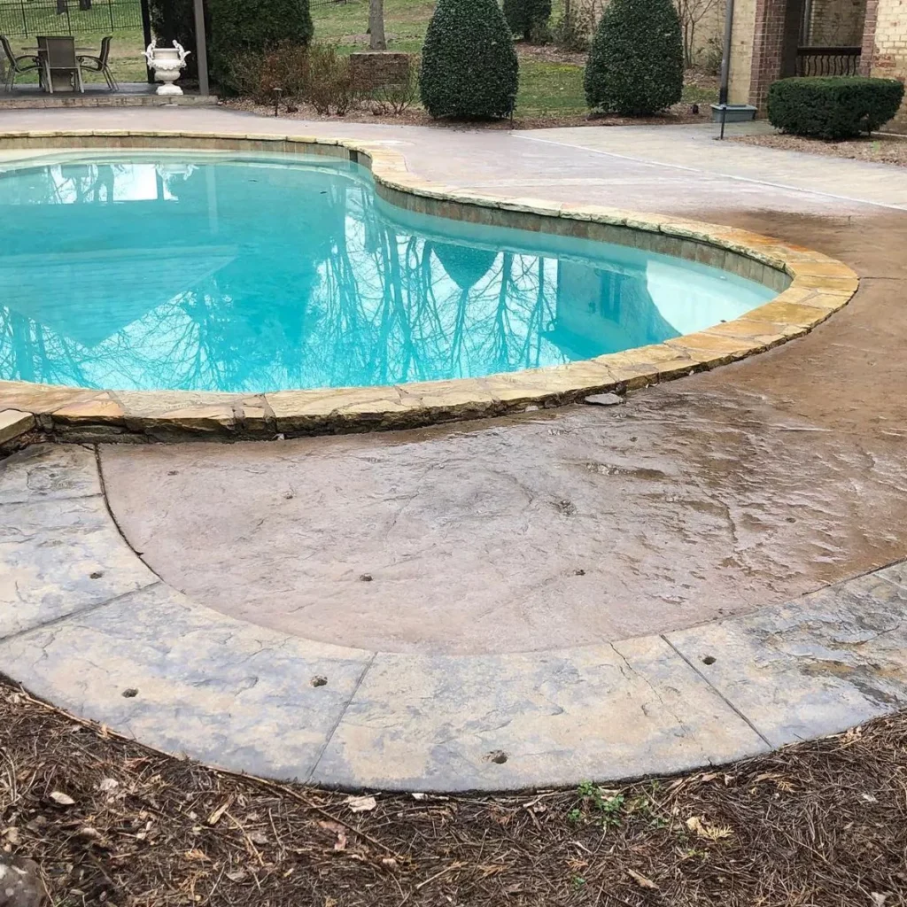 Seamlessly leveled and stabilized decorative stamped concrete pool deck aligned with pool edge.