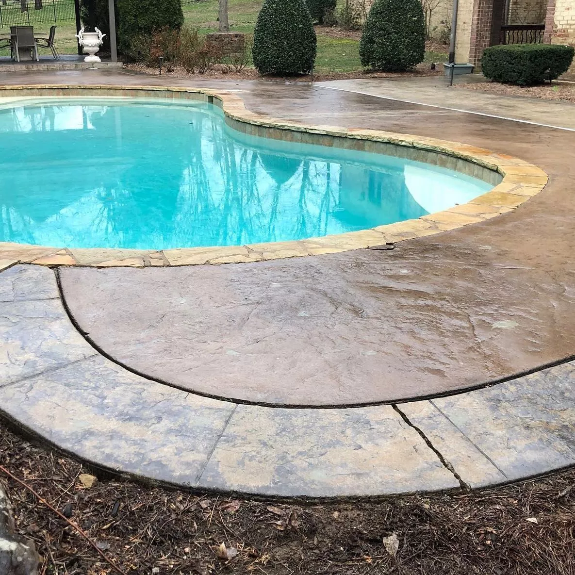 Sinking Stamped Concrete Pool Deck – Before Foam Jacking Cracked and sinking decorative stamped concrete pool deck slab pulling away from pool coping.