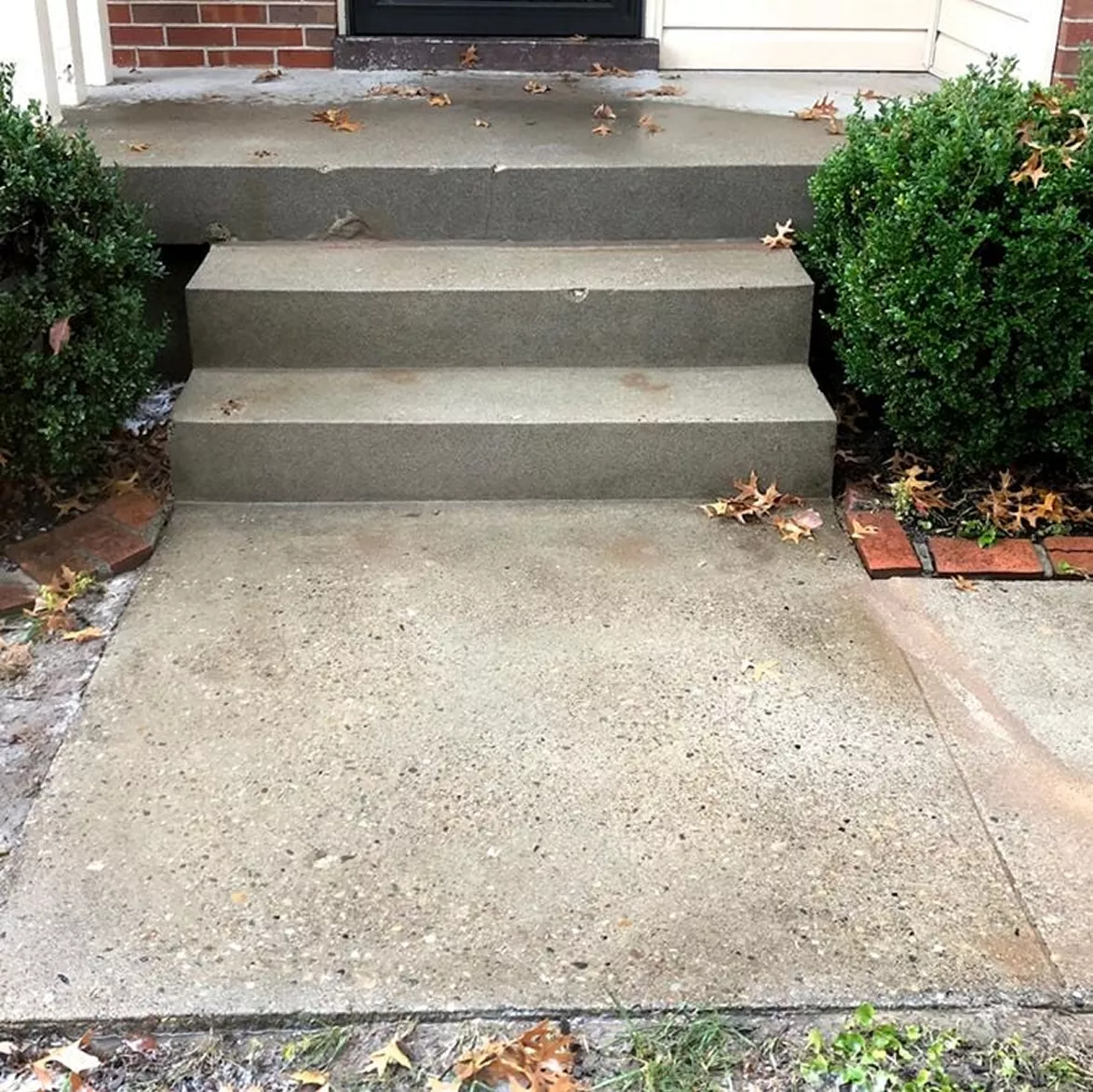 Perfectly leveled concrete front steps with equal tread rise and stable base support.